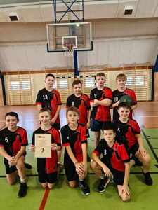 Grupa chłopców w strojach sportowych z dyplomem