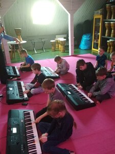 Uczniowie uczą się grać na instrumentach klawiszowych.