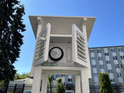 stacja pogody z otwartymi drzwiczkami, za którymi widoczne są przyrządy pomiarowe