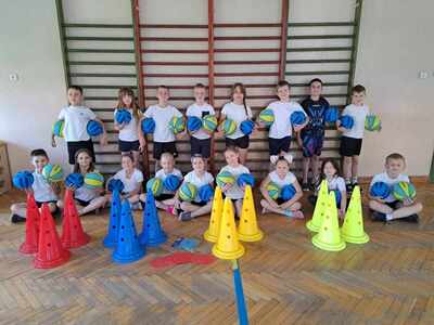 uczniowie w strojach sportowych w auli szkolnej