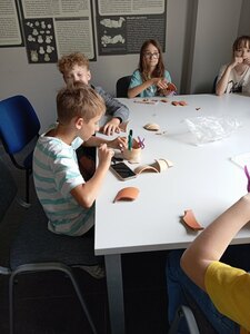 Chłopcy podczas warsztatów bawią się w archeologów
