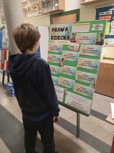 uczeń czyta gazetkę szkolną poświęconą prawom dziecka