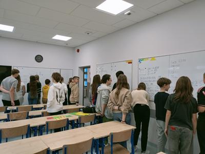Uczniowie klasy 7b poznają metodę „Myślącej klasy” podczas lekcji matematyki,
pracują w małych grupach przy pionowych, suchościeralnych, białych tablicach.