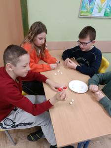 czworo uczniów siedzi przy ławce i buduje model cząsteczki