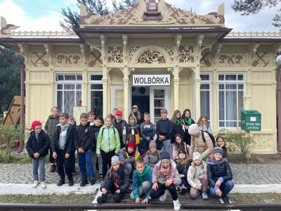 Zdjęcie grupowe przed zabytkowym budynkiem dworca Wolbórka