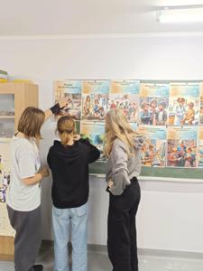 Uczennice klasy 5d umieszczają na tablicy plansze w celu ich dalszej prezentacji.