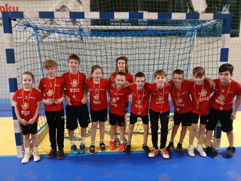 zdjęcie drużyny w czerwonych koszulkach, na tle bramki