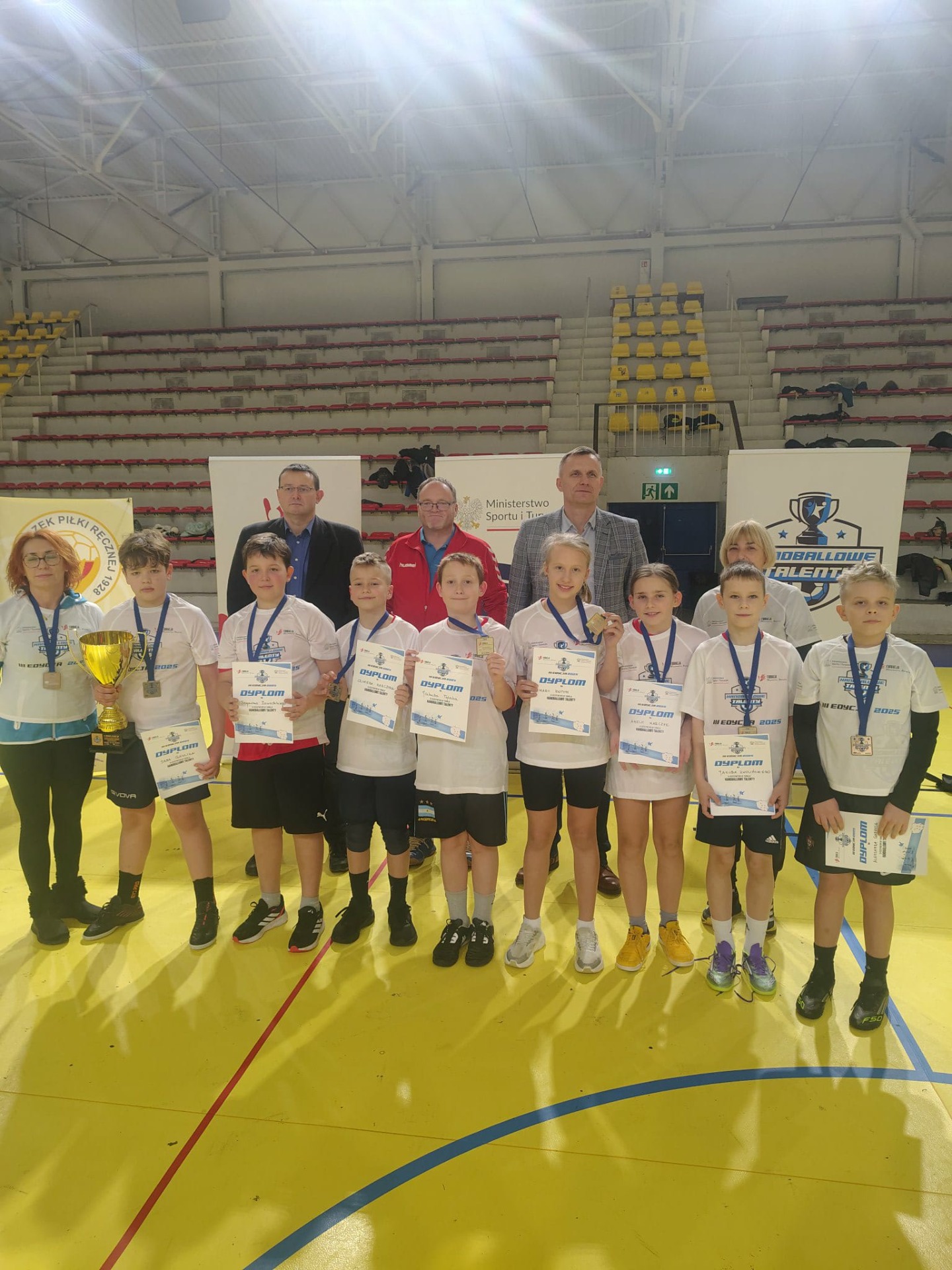 reprezentacja szkoły w hali sportowej z organizatorami turnieju