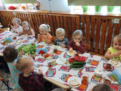 Grupa dzieci spożywających przygotowane samodzielnie śniadanie