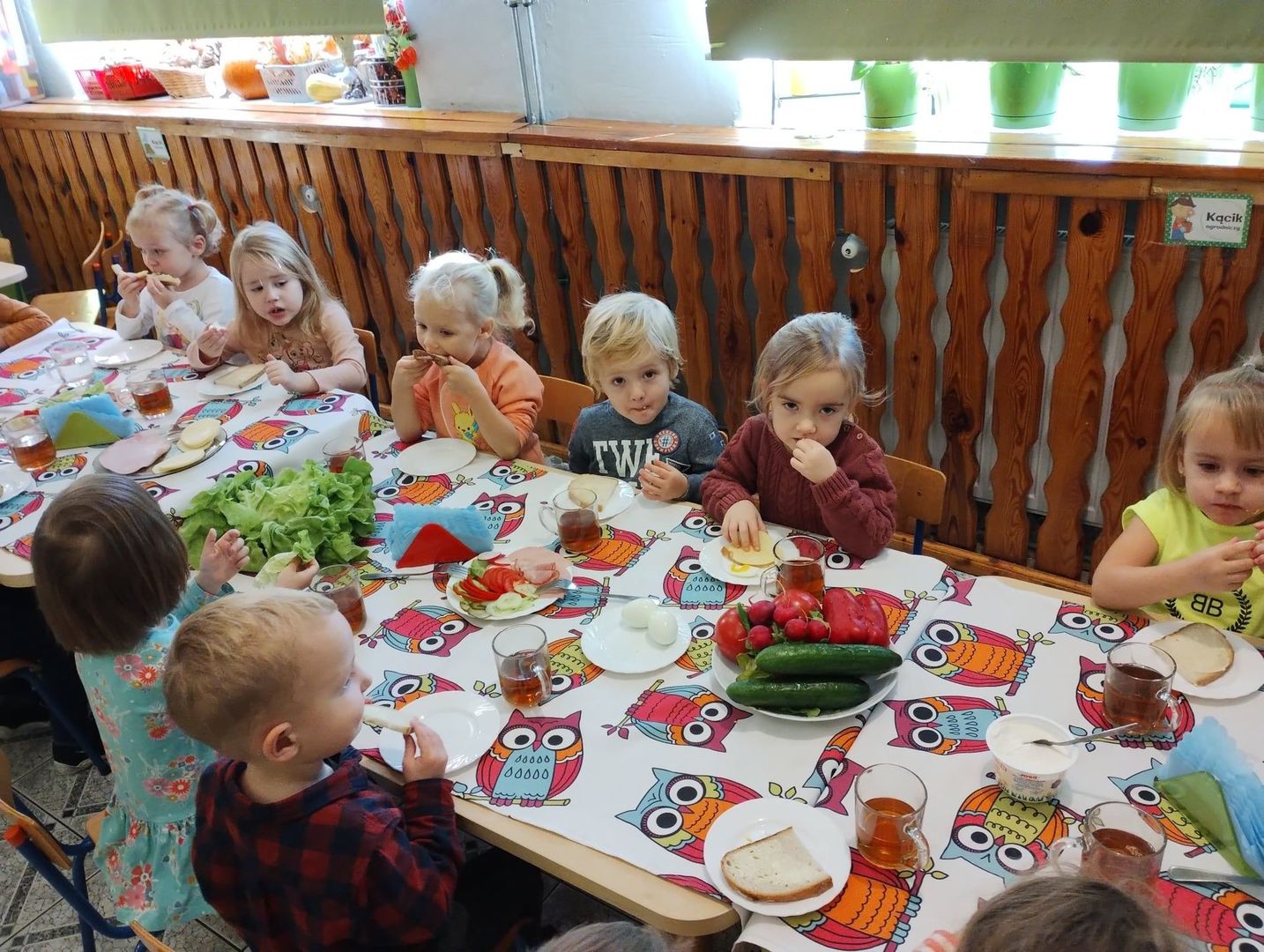Grupa dzieci spożywających przygotowane samodzielnie śniadanie