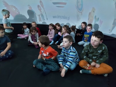 Dzieci siedzące w kopule kina sferycznego