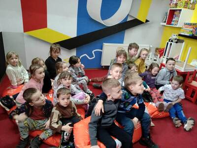 Dzieci z grupy Tygryski siedzą na pufach w bibliotece