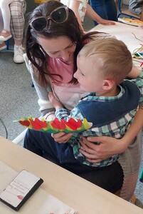 Chłopiec wręcza mamie laurkę z kwiatami