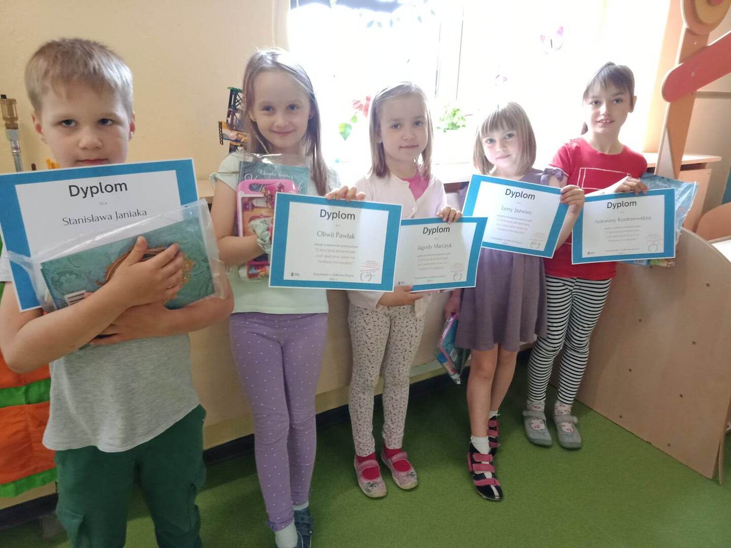 Pięcioro dzieci pozuje z dyplomami konkursowymi