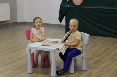 Dziewczynka i chłopiec siedzą przy stoliku.