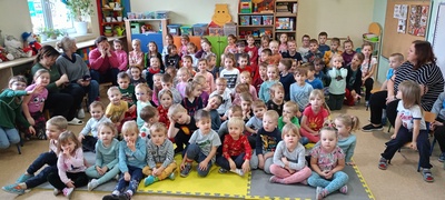 Grupa dzieci siedzi na macie.