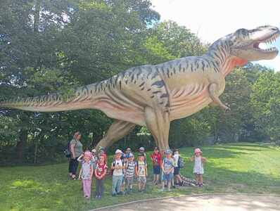 Dzieci pozują przy ogromnym T-rexie