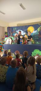 Dzieci oglądają przedstawienie kukiełkowe.