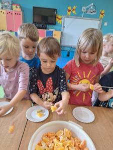 Dziewczynki samodzielnie przygotowują szaszłyki z owoców m.in. mandarynek