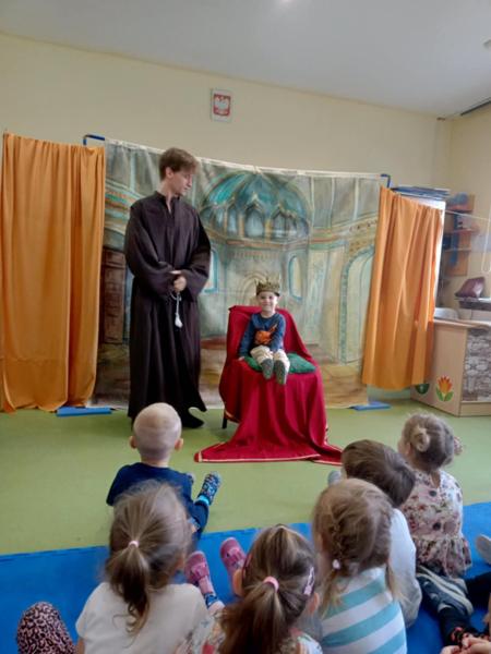 Mały chłopiec siedzi na tronie w czasie przedstawienia 