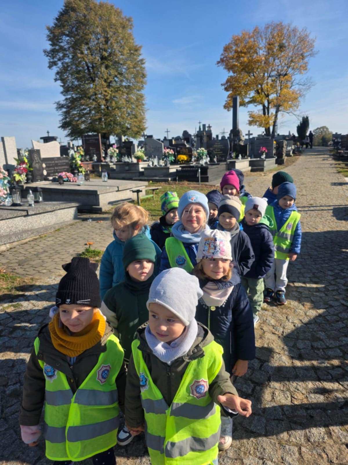 Grupa Kangurki idzie parami na cmentarzu