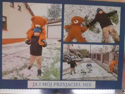Chłopiec bawi się z misiem na śniegu.