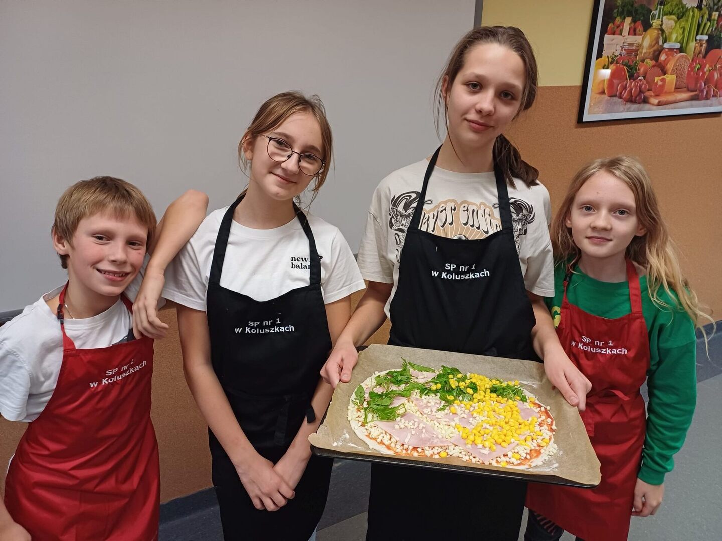 Dziewczynki i chłopiec prezentują wykonaną pizzę