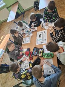 Uczniowie klasy III siedzą wspólnie przy stolikach i tworzą swoje awatary.