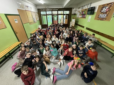 Zdjęcie grupowe przedstawia uczniów mających kwiaty we włosach.