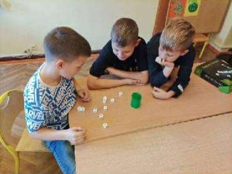 Młodsi uczniowie ćwiczą umysły na grach stolikowych. 