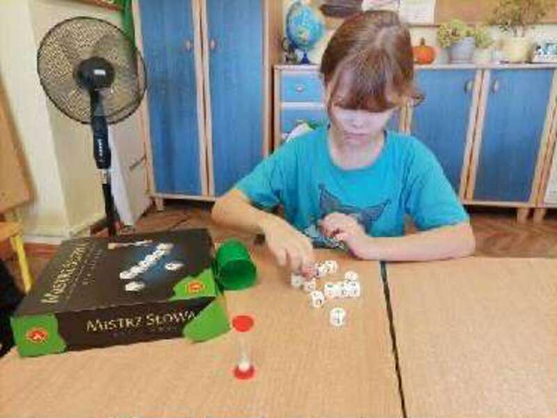 Młodsi uczniowie ćwiczą umysły na grach planszowych. 