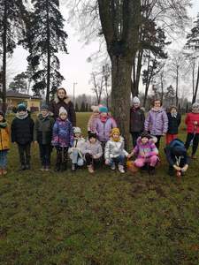 Uczniowie stoją na tle drzewa