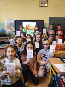 Uczniowie klasy 2a, w tle na tablicy interaktywnej logo "Kubusiowi Przyjaciele Natury"