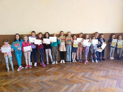 Uczestnicy konkursu talentów stoją obok siebie. Trzymają dyplomy i nagrody. 