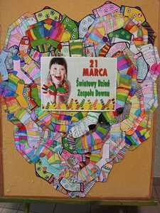 Plakat z napisem " 21 marca Światowy Dzień Zespołu Downa" zawieszony na sercu z kolorowych skarpet. 