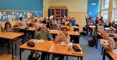 Uczniowie z wykonanymi przez siebie kleksami. 