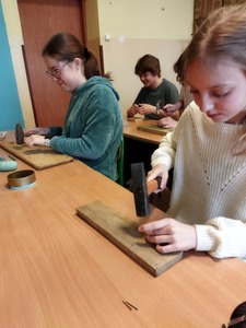 Uczniowie wbijają gwoździe. 