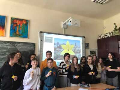 Uczniowie z żonkilami wykonanymi z papieru. 