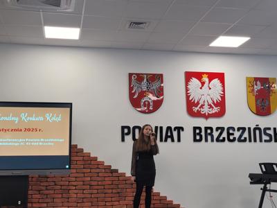 Uczennica przezntuje wybraną koledę. 