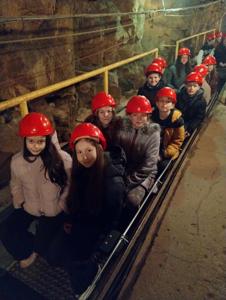 Uczniowie płyną łódką w sztolni. 