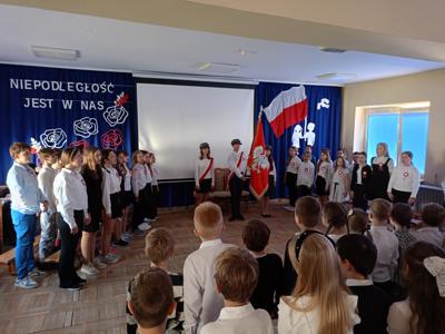 Poczet Sztandarowy i uczniowie klas piątych podczas akademii z okazji Święta Niepodległości