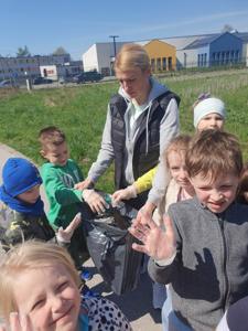 Grupa dzieci zbierająca śmieci na trawniku