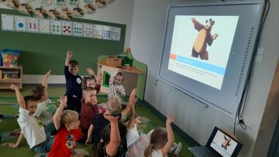 dzień pluszowego misia , grupa dzieci oglądająca bajki w których jest mis