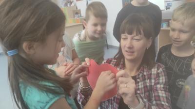 dziewczynka wróżąca, wbijająca szpilkę w serduszko które trzyma wychowawca