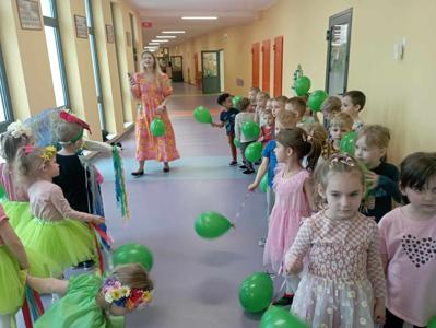 dzieci idące parami z zielonymi balonami podczas powitania wiosny