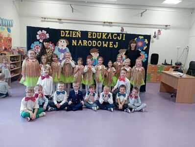 grupa na występach w tle napis dzień edukacji narodowej