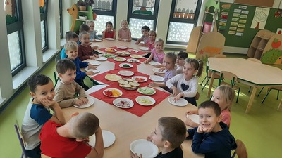 dzieci przy stolikach same robią sobie śniadanie