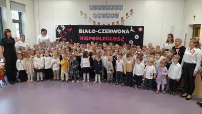 dzieci z całego przedszkola stoją na baczność i śpiewają hymn polski