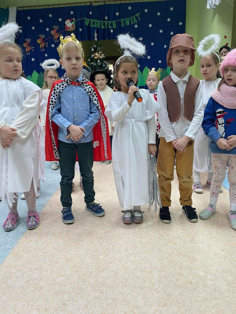Dziewczynki w strojach aniołków oraz pasterz i król recytują wiersze.