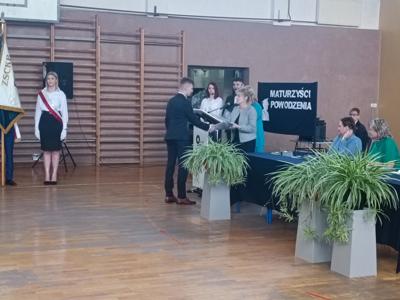 Uczeń przekazujący kwiaty nauczycielce
